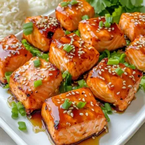 - 1 pound fresh salmon fillet, skin removed and cut into bite-sized cubes - 1/4 cup teriyaki sauce (store-bought or homemade) - 1 tablespoon honey for sweetness - 1 tablespoon sesame oil for richness - 2 cloves fresh garlic, minced finely - 1 teaspoon freshly grated ginger for an aromatic touch - 1 tablespoon sesame seeds for garnish - 2 green onions, finely chopped for freshness - Salt and pepper to taste Using fresh salmon fillets makes a big difference in taste. Cut them carefully into cubes, about one inch each. The salmon bites soak up the teriyaki flavor well. You can use store-bought teriyaki sauce or make your own. I often mix soy sauce, brown sugar, and a dash of rice vinegar for a quick version. Adding honey gives the bites a sweet touch. It balances the salty teriyaki sauce nicely. Sesame oil brings a rich, nutty flavor that enhances the dish. For aromatics, fresh garlic and ginger really shine. Mince the garlic finely for a stronger taste. Grate the ginger to release its oils. Garnish with sesame seeds for crunch. They add a nice texture. Green onions are perfect for freshness and color. You can also sprinkle salt and pepper for extra flavor. Adjust these to your taste. This ingredient list is simple, yet every item plays an important role. Each bite bursts with flavor. To start, gather your ingredients. In a medium bowl, combine the teriyaki sauce, honey, sesame oil, minced garlic, and grated ginger. Whisk these together until smooth. This marinade packs a punch of flavor and is key to making the salmon delicious. Next, take your salmon fillet and cut it into bite-sized cubes. Coat each cube in the marinade. Make sure each piece is covered well. Cover the bowl with plastic wrap or a lid. Let it marinate in the fridge for 15 minutes. This step helps the salmon soak up all those tasty flavors. After marinating, preheat your air fryer to 380°F (193°C). Let it heat for about 5 minutes. This ensures a good cooking temperature. Once hot, remove the salmon from the fridge. Pat the salmon cubes dry with a paper towel. This step helps the outside get crispy. Arrange the salmon bites in the air fryer basket. Make sure to space them out. Avoid overcrowding the basket for even cooking. Cook the salmon for 8-10 minutes. Shake the basket halfway through. The bites are ready when they are cooked through and slightly crispy on the edges. Carefully remove the salmon bites from the air fryer. Drizzle any leftover marinade over them. Garnish with sesame seeds and chopped green onions. A sprinkle of salt and pepper adds the final touch. Enjoy your tasty snack! Patting the salmon cubes dry is key. Moisture makes it hard for the salmon to crisp up. Use a paper towel to gently press on the cubes. This step helps achieve a crunchy exterior. It also allows the marinade to stick better. Do not overcrowd the air fryer basket. Spacing the salmon bites allows hot air to circulate. This circulation is important for even cooking. If you add too many pieces, they might steam instead of fry. Cook in batches if needed for the best results. You can change the marinade to fit your taste. Want it sweeter? Add more honey. Prefer spicy? Try adding Sriracha or red pepper flakes. This flexibility makes the recipe fun and personal. You can create a unique flavor every time you cook! {{image_4}} You can change the flavor of your teriyaki salmon bites by using different marinades. A homemade teriyaki sauce is easy to make. Just mix soy sauce, brown sugar, garlic, and ginger. This gives you a fresh taste. If you like heat, add Sriracha or red pepper flakes. This will spice things up and wake up your taste buds. Just a little will do! If you want to switch things up, try chicken or tofu. Chicken works well with teriyaki flavors too. Just cut it into bite-sized pieces like the salmon. Tofu is a great option for a plant-based meal. Use firm tofu for the best texture. Marinate it just like the salmon. Pair your teriyaki salmon bites with vegetables for a healthy meal. Steamed broccoli or carrots complement the flavors nicely. You can also serve them with rice. Fluffy white or brown rice soaks up the teriyaki sauce well. A fresh salad can add a crunchy touch. Enjoy your meal! To keep your teriyaki salmon bites fresh, store them in an airtight container. Make sure the lid seals tightly. This helps keep moisture and flavors locked in. Place the container in your fridge. Leftovers will stay good for up to three days. If you want to enjoy them later, storing them right is key. The best way to reheat your salmon bites is in the air fryer. Preheat the air fryer to 350°F (175°C). Place the salmon bites in the basket in a single layer. Heat them for about 5 minutes. This method keeps them crispy, just like when you first cooked them. You can also use the microwave, but this may make them soggy. If you want to freeze your salmon bites, let them cool first. Spread them on a baking sheet in a single layer. Freeze them for about an hour. Once frozen, transfer them to a freezer-safe bag or container. Make sure to remove as much air as possible. They can stay in the freezer for up to two months. To thaw, place them in the fridge overnight. You can then reheat them in the air fryer for a quick snack. To check for doneness, look for a few signs. The salmon should be opaque and flake easily with a fork. The ideal internal temperature is 145°F (63°C). Use a meat thermometer for an accurate read. When the edges of the salmon bites look crispy, they are ready to eat. Yes, you can use frozen salmon. Just make sure to thaw it completely before marinating. This helps the marinade soak in well. You can thaw salmon in the fridge overnight or use the microwave for a quick option. Pat the salmon dry before adding it to the marinade. This helps achieve that crispy texture. There are many delicious sides to pair with teriyaki salmon bites. Here are some great options: - Steamed rice for a filling base - A fresh salad with crisp veggies - Roasted vegetables for added flavor - Noodles tossed in soy sauce or sesame oil These sides will complement the rich flavors of the salmon perfectly. Enjoy your meal! In this article, we discussed how to make delicious teriyaki salmon bites. We covered essential ingredients like fresh salmon, teriyaki sauce, and seasonings. I shared step-by-step instructions for preparing the marinade and air frying the salmon. I also gave tips for achieving the perfect crispiness and offered variations for different tastes. Remember, you can store leftovers properly and reheat them easily. With these steps, you can enjoy tasty salmon bites that suit your flavor preferences. Enjoy cooking and sharing these bites with friends and family!